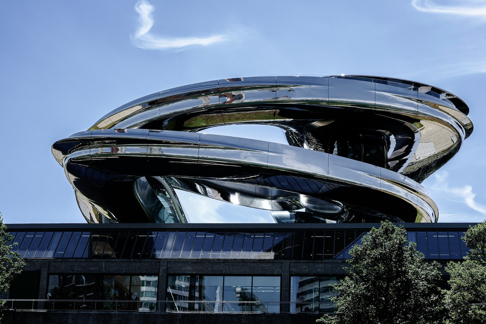 A sculptural stainless-steel museum facade against a blue sky
