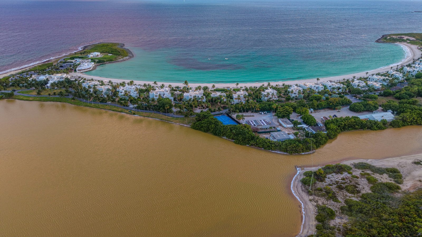 A turquoise lagoon and white resort buildings on the Red Sea coast