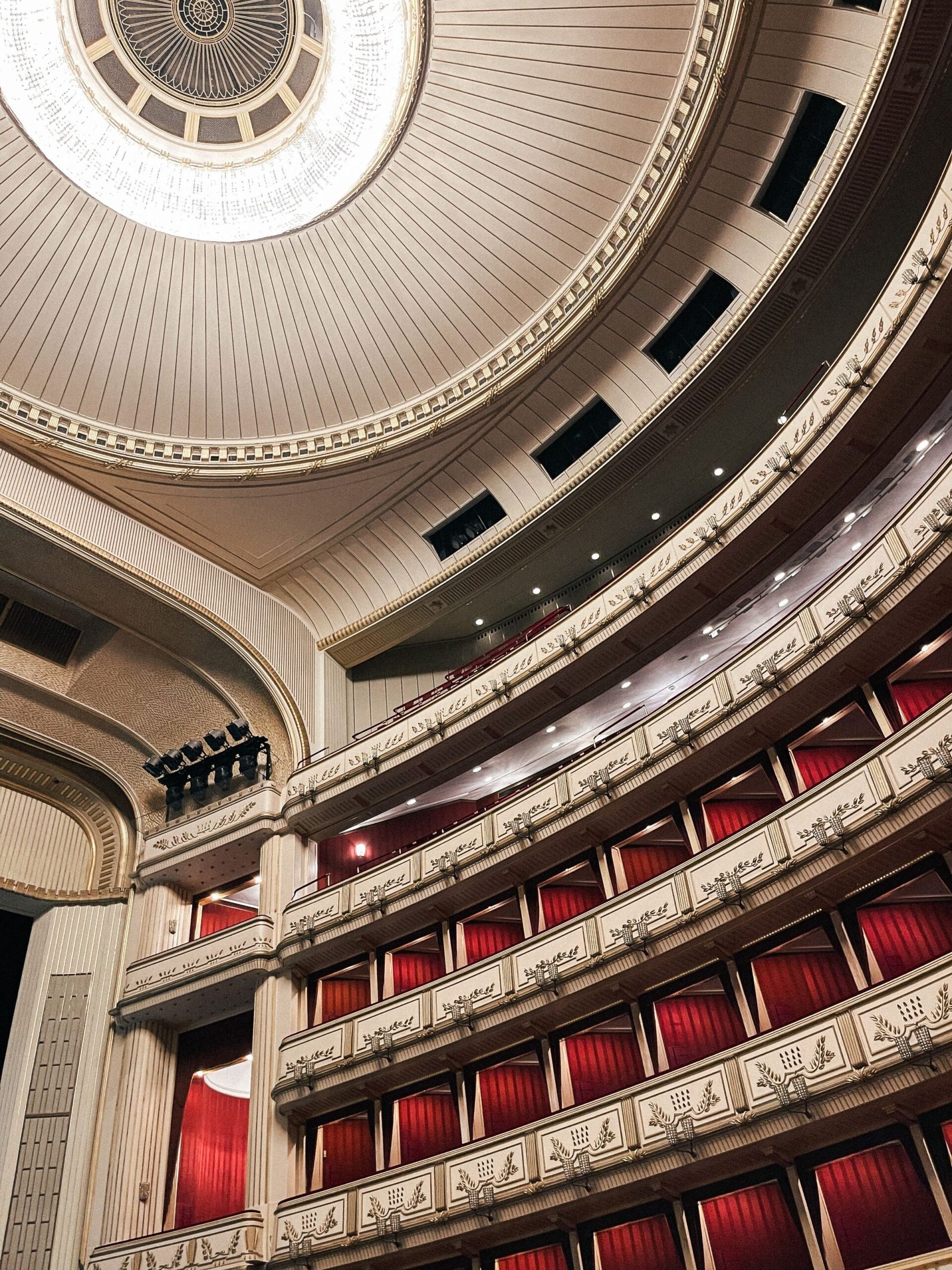An opera house auditorium with red seats and gilded balconies