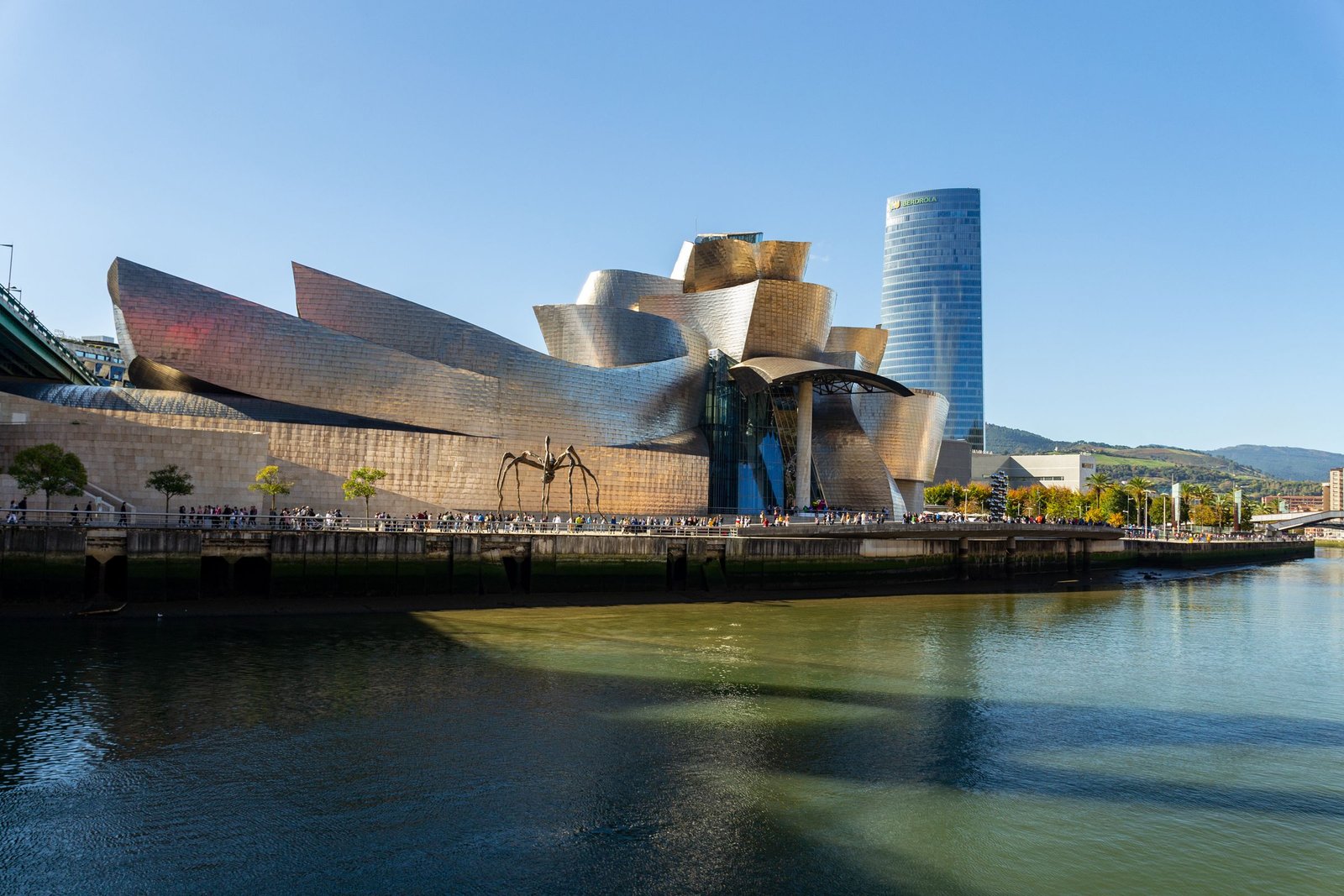 The curving titanium forms of the Guggenheim Museum Bilbao beside the river