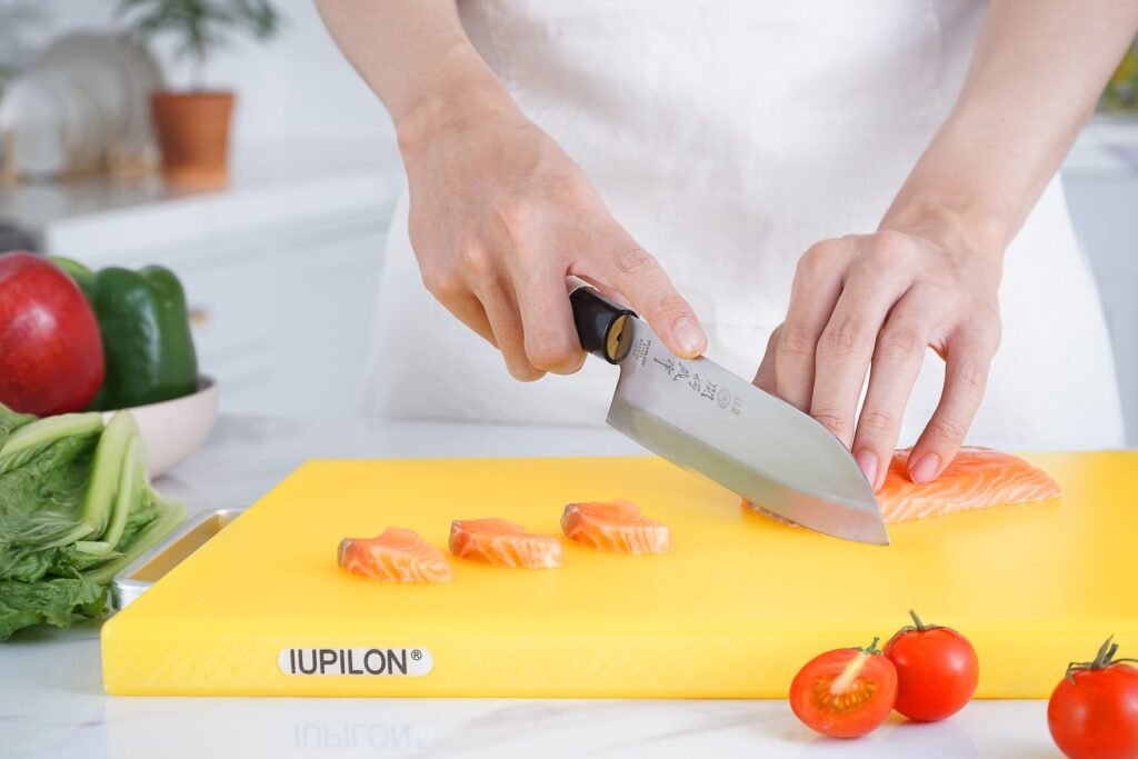 A chef slicing fish at a sushi counter