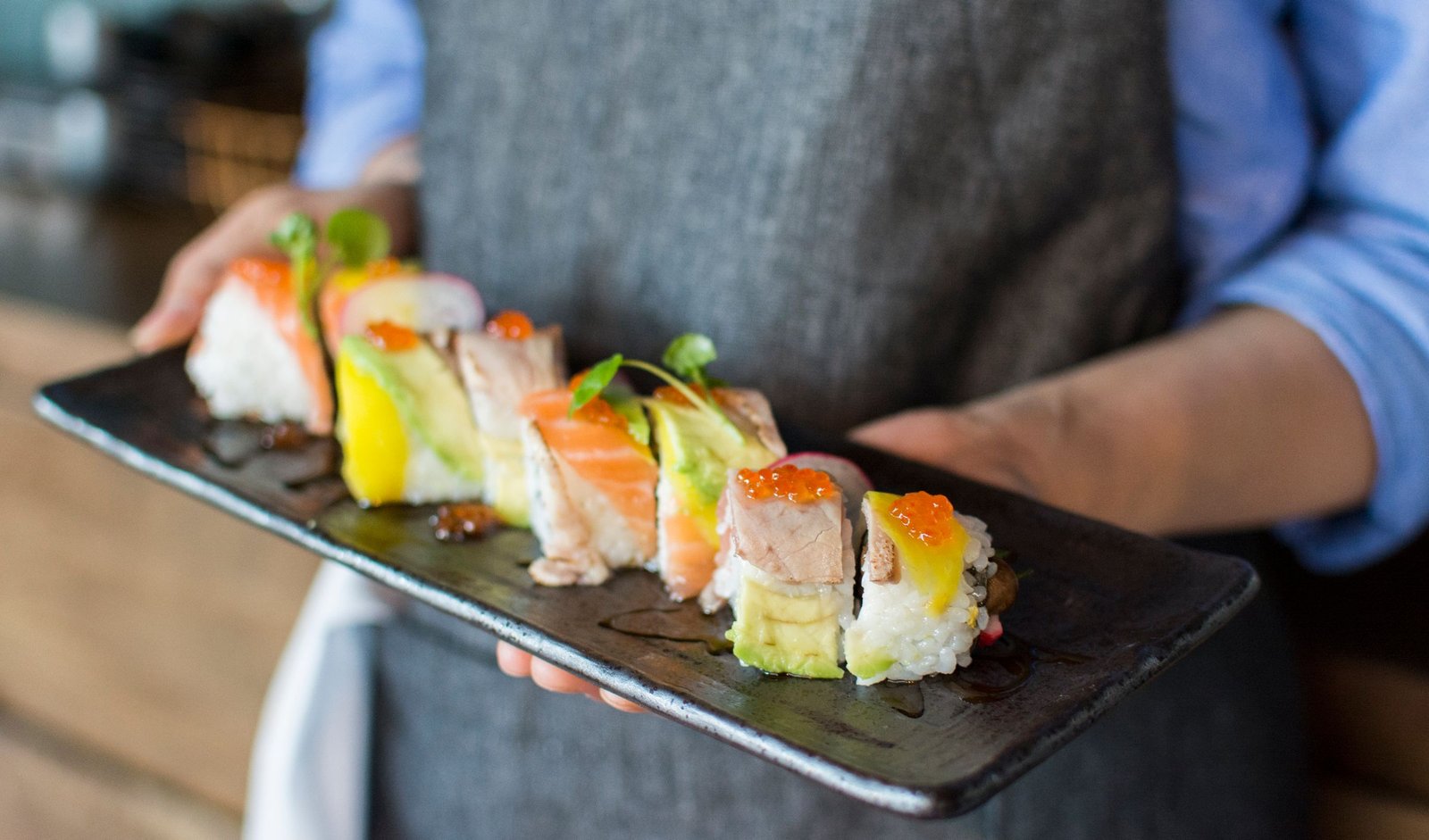 Nigiri sushi on a dark ceramic plate