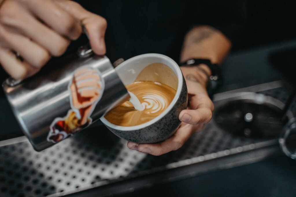 Latte art being poured into a coffee cup