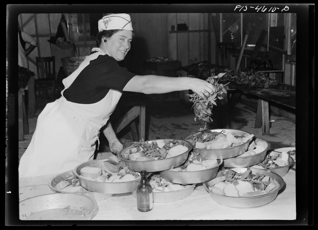 A chef's hands finishing a plate in a restaurant kitchen