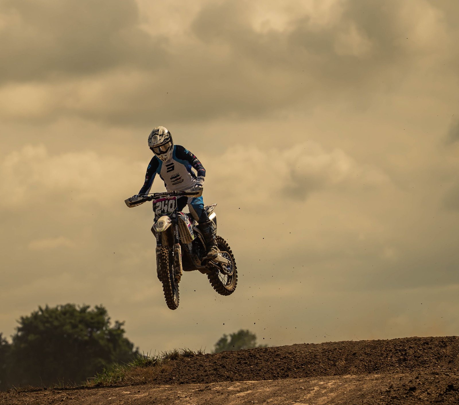 A motocross rider in mid-air over a dirt track