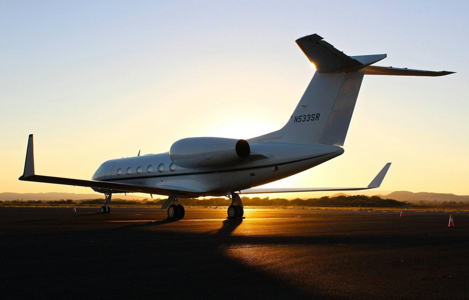 A private jet parked on an airport apron at sunset