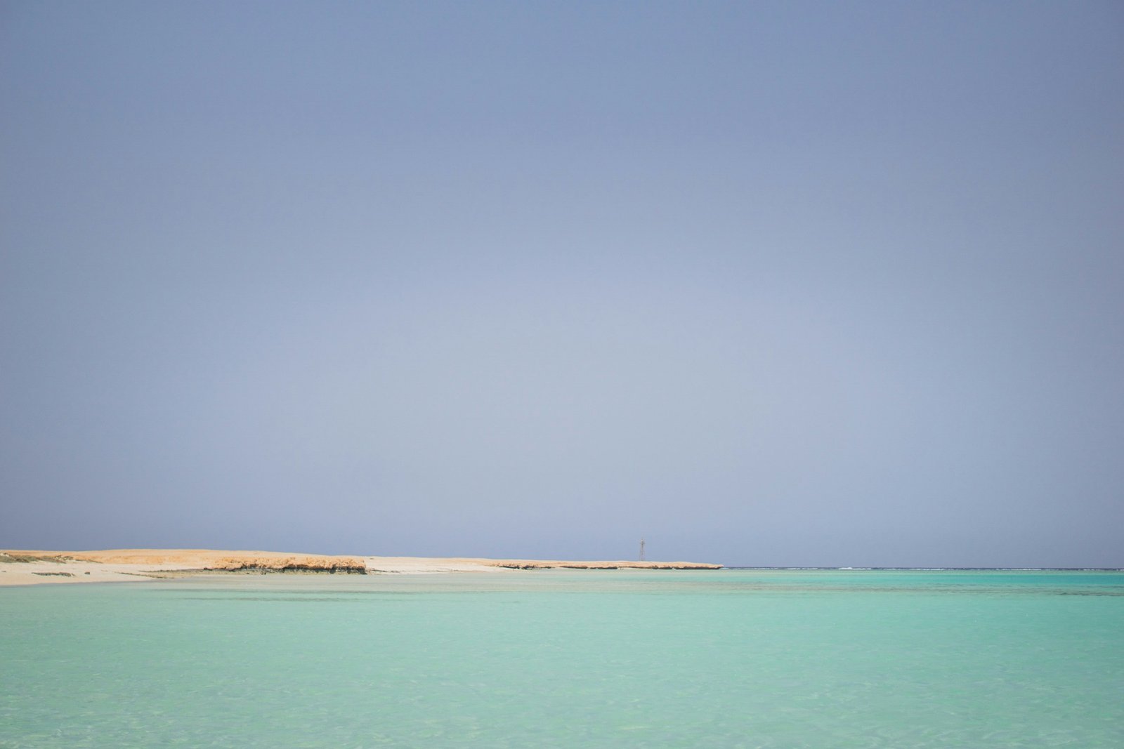 A sandbar in shallow turquoise water off the coast