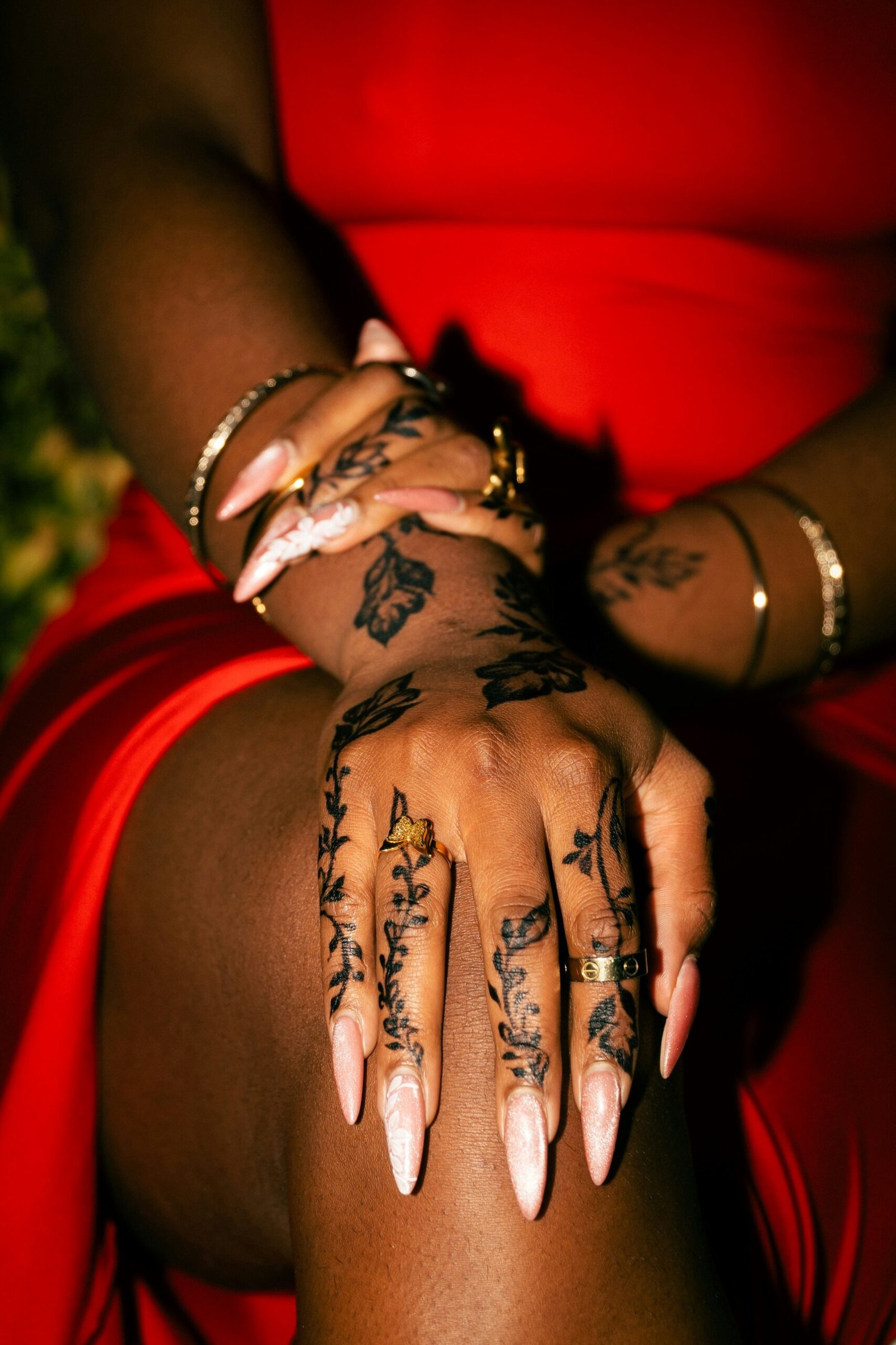 Hands decorated with henna patterns and wearing gold rings