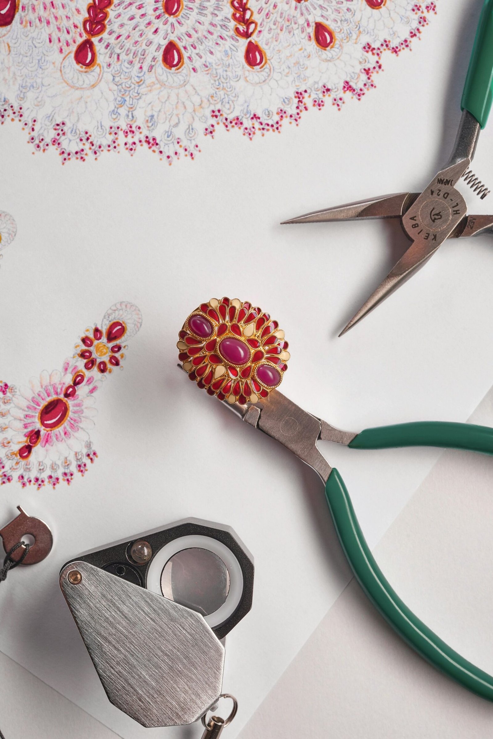 A jeweller’s workbench with design sketches and small tools