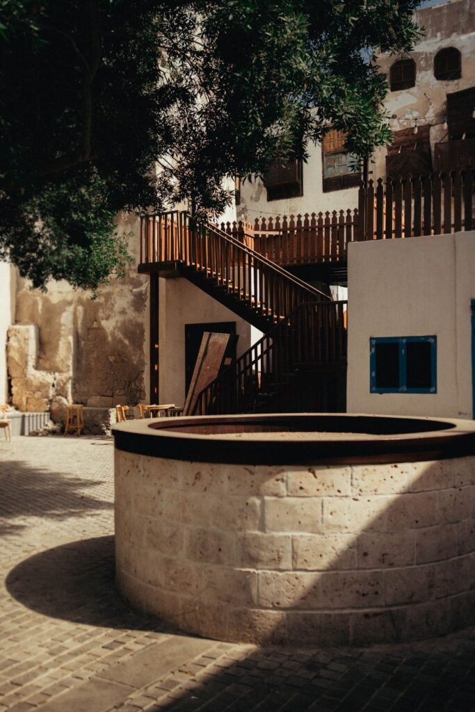A sunlit courtyard with arches and warm stone walls