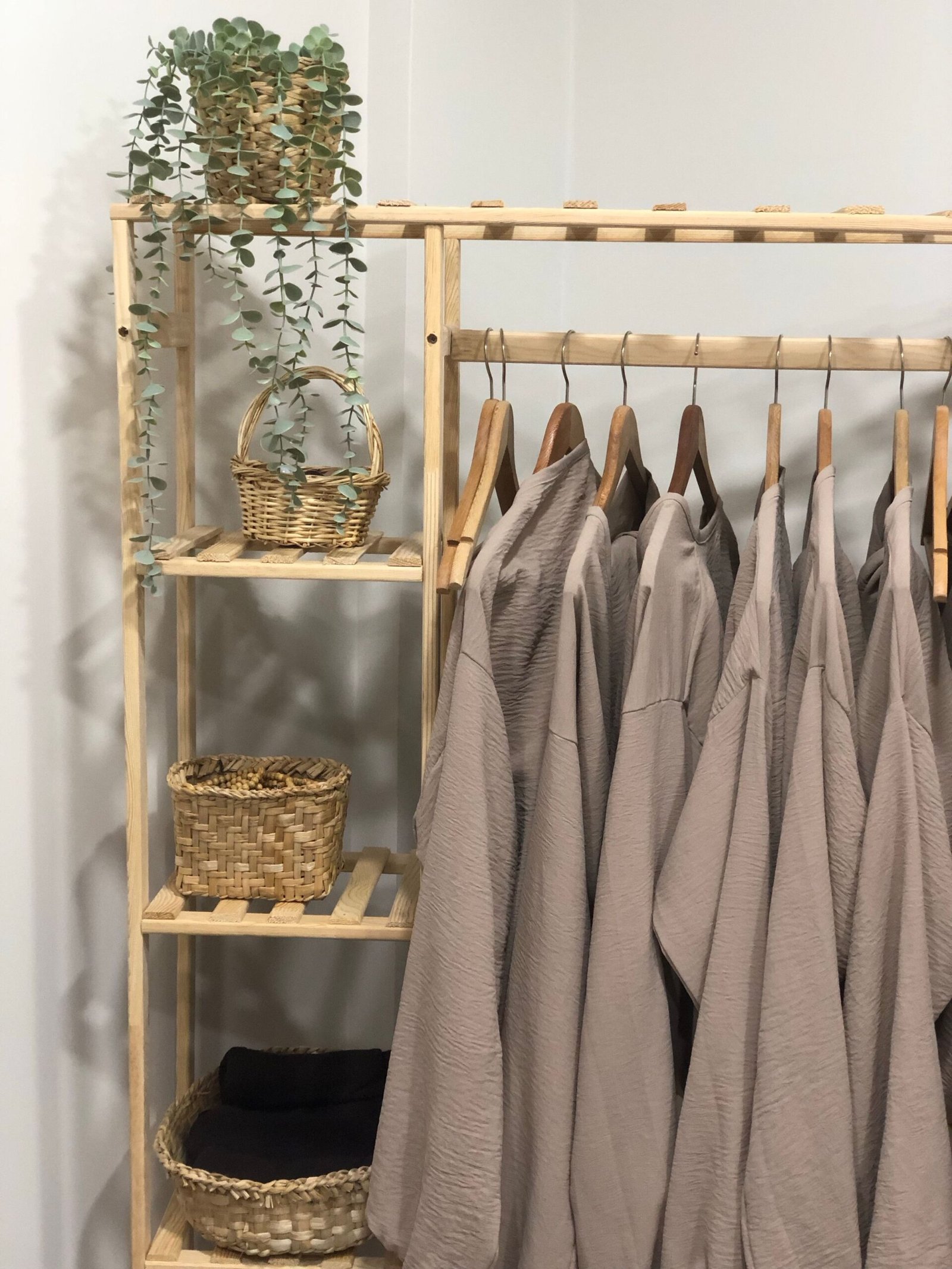 A rail of pale linen and silk garments in bright light