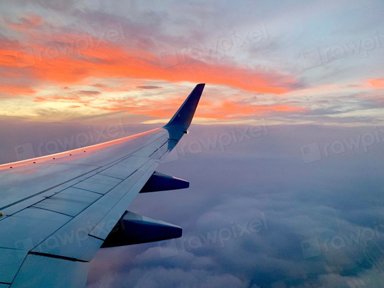 An aircraft wing above the clouds at sunset