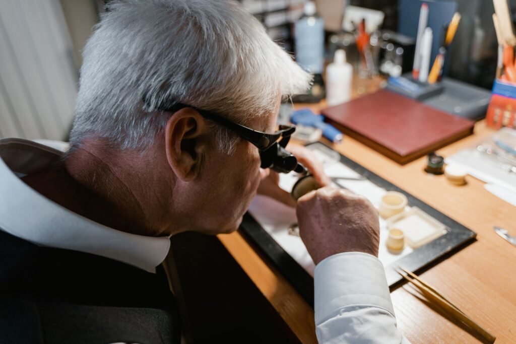 A watchmaker examining a watch through a loupe in his workshop