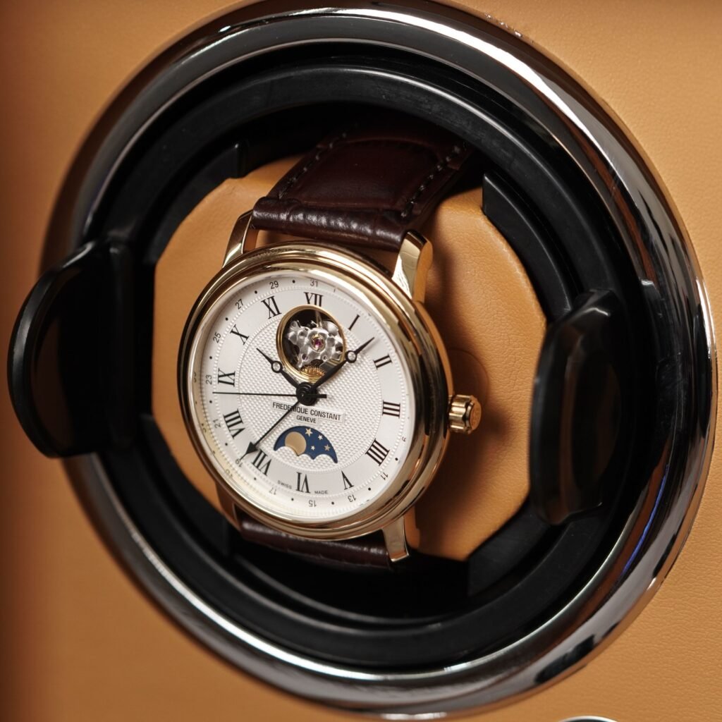 A dress watch with a moon phase display, on a leather strap in its box