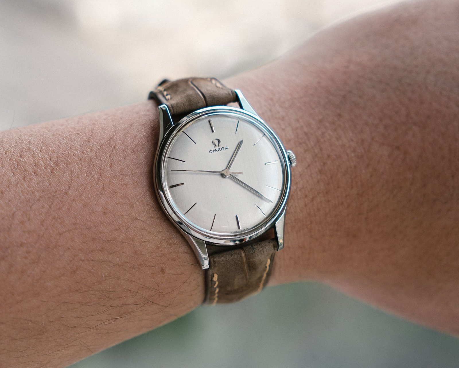 A classic watch on a brown leather strap, worn on the wrist