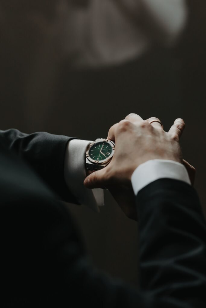 A green-dial watch on the wrist of a man in a suit