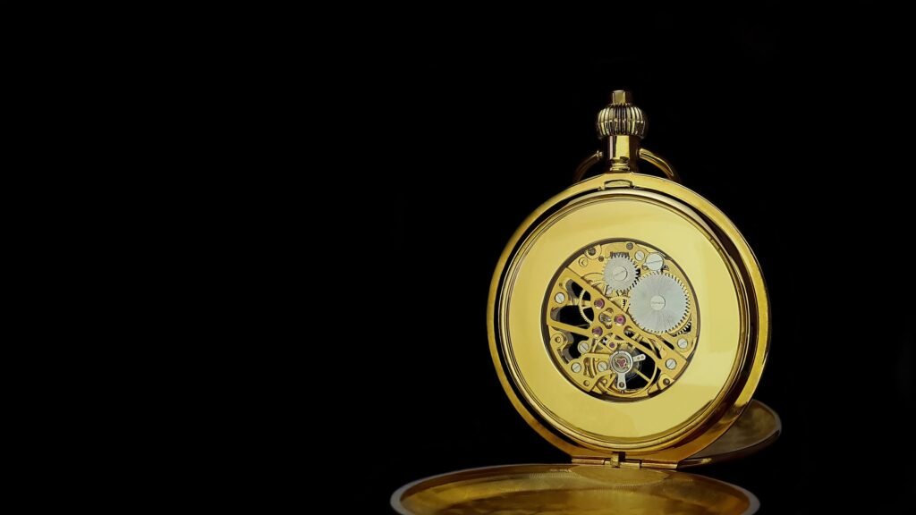 An antique pocket watch with its caseback open, showing the movement