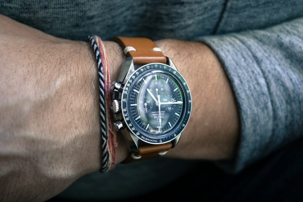 A Speedmaster on a brown leather strap worn on the wrist