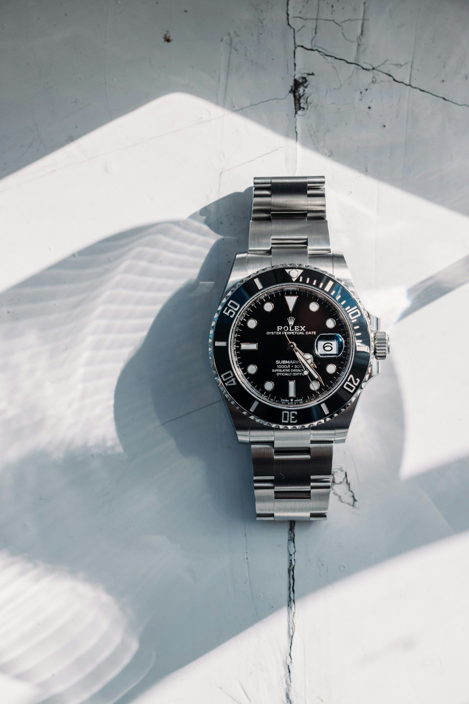 A Rolex Submariner Date with a black dial and black bezel on a white surface