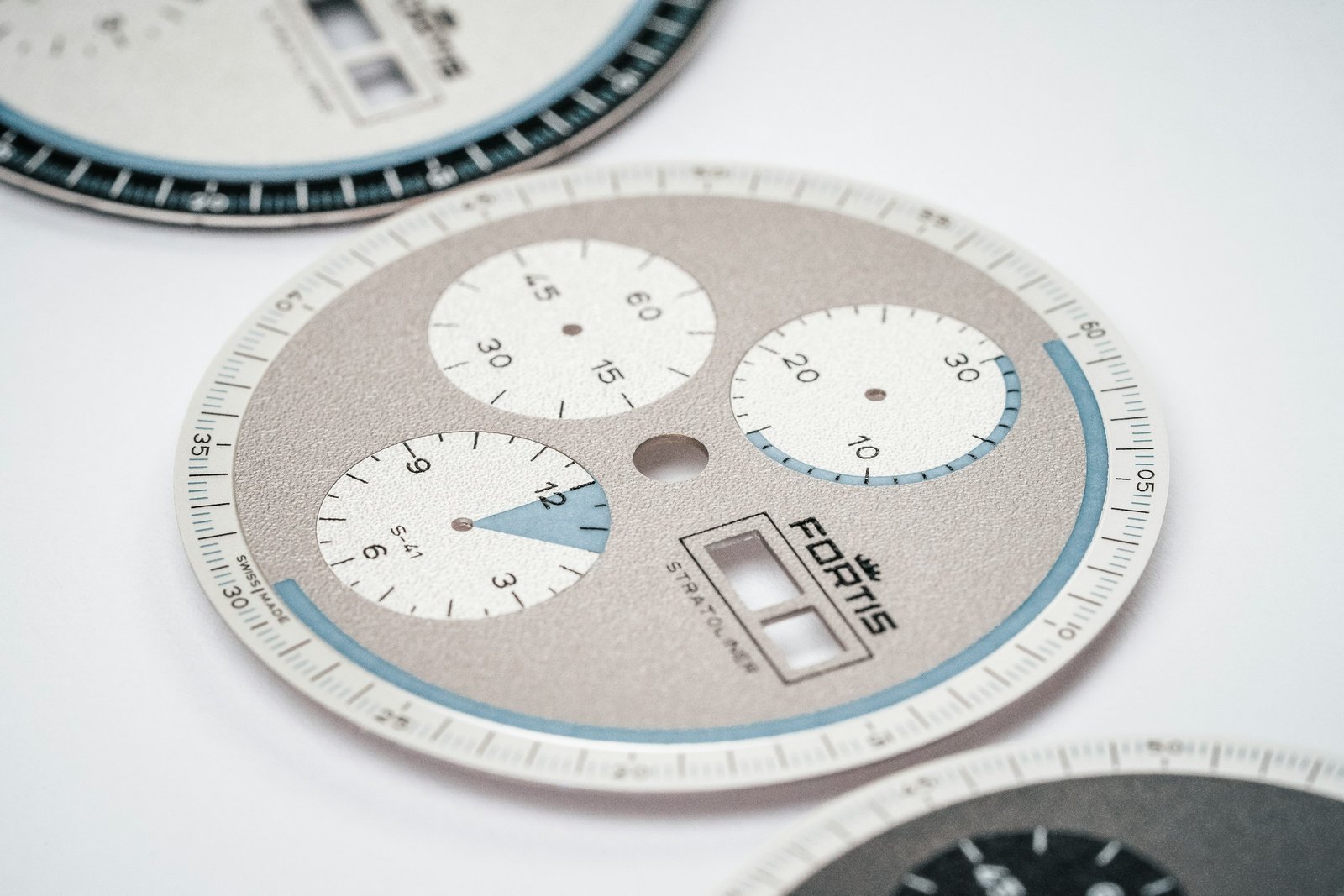 Watch dials laid out on a watchmaker’s bench
