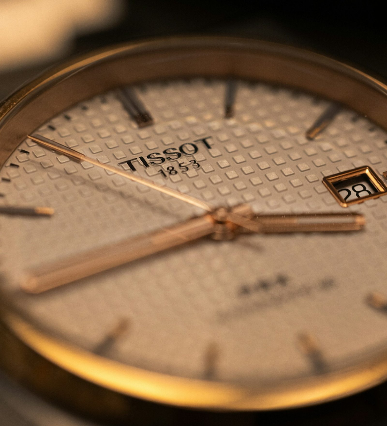 A gold Tissot wristwatch on a workbench